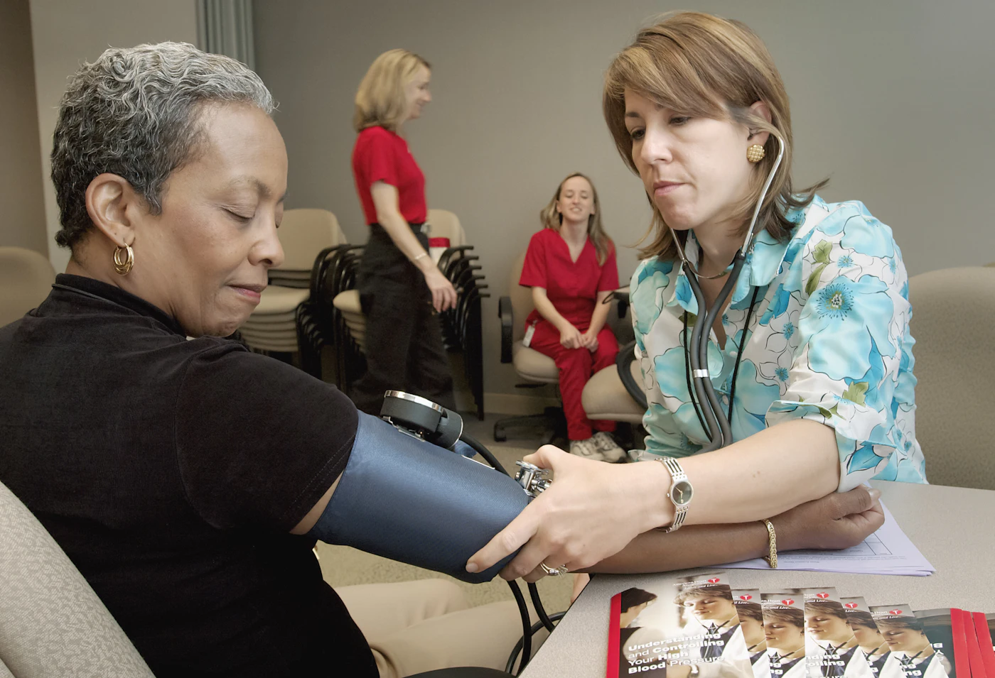 A provider checking a patient's blood pressure during a physical
